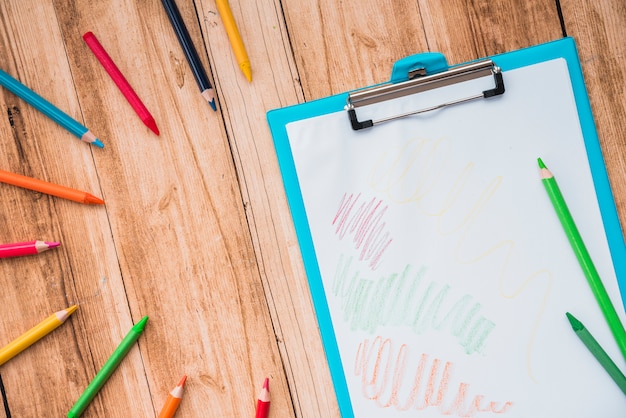 Kostenloses Foto bunter bleistift und klemmbrett mit weißbuch auf holztisch