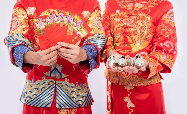 Kostenlose Foto chinesisches neujahr, geschenkgeld und bargeld werden bekommen - geben sie männern und frauen, die cheongsam für traditionelle tragen