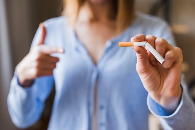 Kostenloses Foto defocus frau zeigte auf defekte zigarette