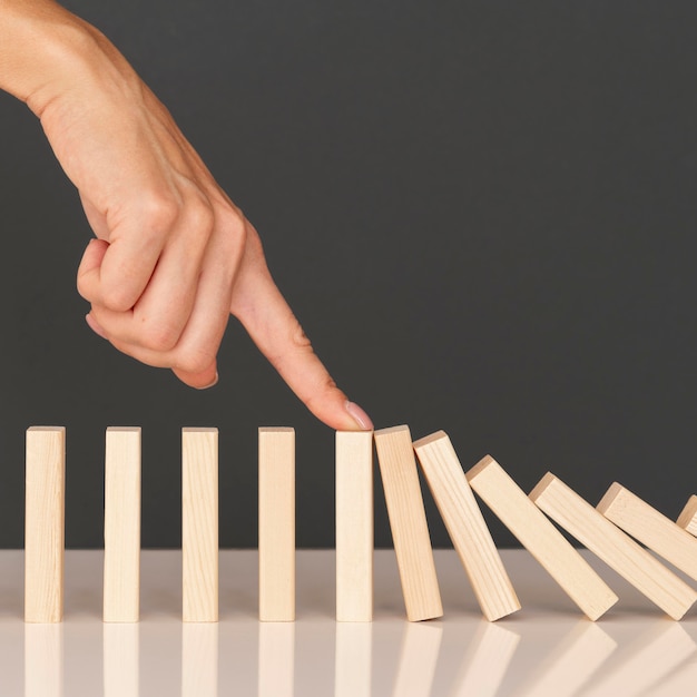 Kostenlose Foto domino-spiel mit holzstücken, die finanzielle kämpfe darstellen