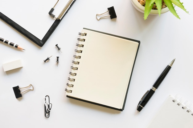 Kostenloses Foto draufsicht auf büromaterial mit notizbuch und stiften