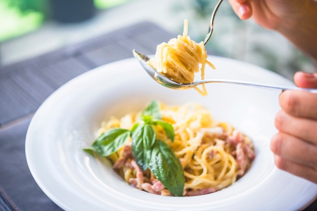 Kostenloses Foto eine person, die appetitanregende spaghettis hält, rollte auf gabel