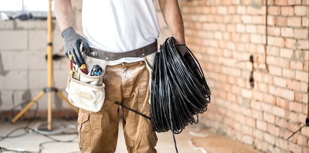 Kostenloses Foto elektriker mit werkzeugen, auf einer baustelle arbeitend. reparatur- und handwerker-konzept.