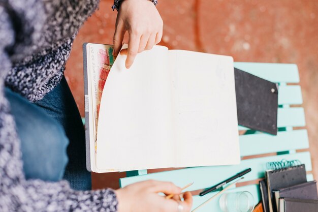 Erneuern Sie die Frau, die Seiten des Sketchbooks dreht