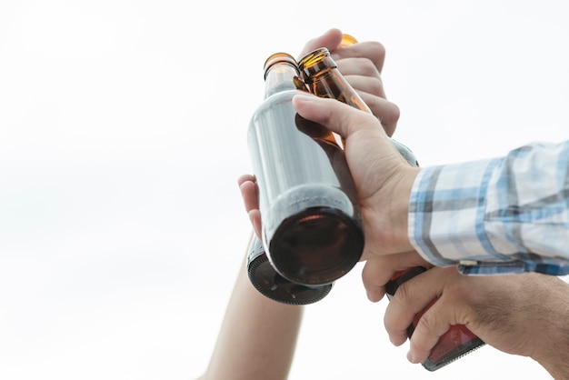 Kostenlose Foto ernten sie hände von den männern, die flaschen bier klirren