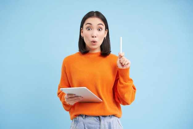 Kostenlose Foto eureka hatte eine idee, aufgeregte asiatische frau mit digitalem tablet, die den stift hochhebt, bekam eine offenbarung, die großartig ist