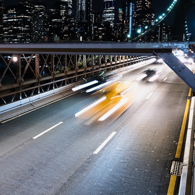 Kostenloses Foto fahrzeuge auf der brücke mit bewegungsunschärfe in der nacht