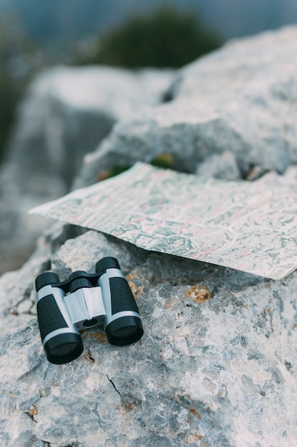 Kostenloses Foto fernglas und karte auf felsen