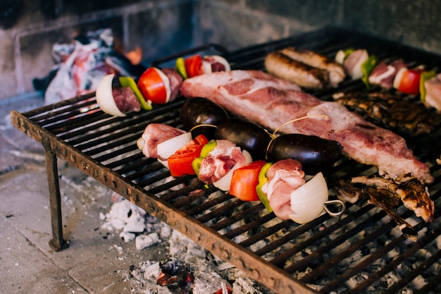 Kostenloses Foto fleisch und gemüse auf heißen kohlen grillen