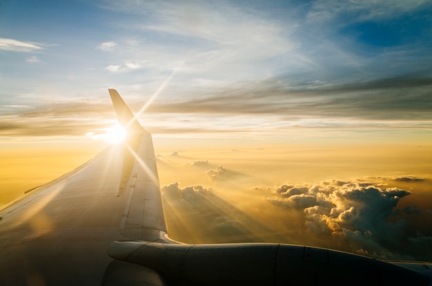 Kostenloses Foto flügel des flugzeuges am blauen himmel in der dämmerung und sonnenuntergang