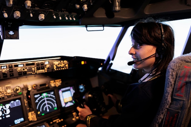 Kostenloses Foto flugbesatzungsmitglied fliegt flugzeug vom cockpit aus mit dashboard-befehls- und bedienfeld, mit lenkrad und bedienfeld für die windschutzscheibennavigation. frau, die hebel verwendet, um flugzeuge zu fliegen.