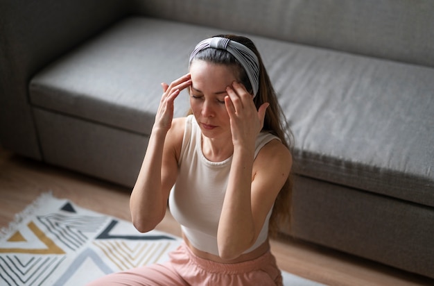 Kostenloses Foto frau aus dem hohen winkel, die gesichtsyoga praktiziert