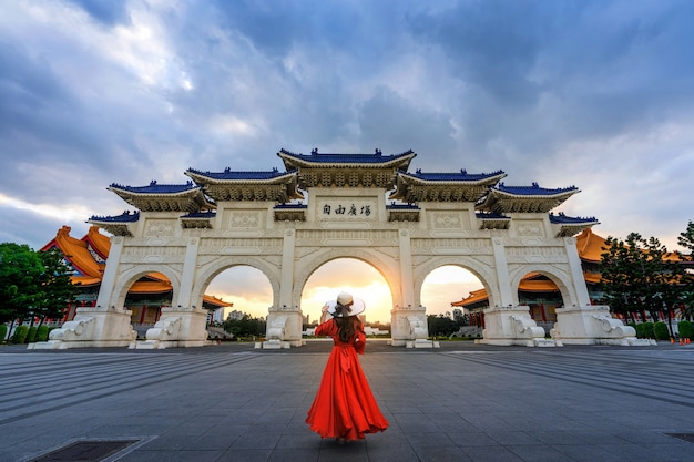 Kostenloses Foto frau, die am torbogen der chiang kai shek memorial hall in taipeh, taiwan geht.