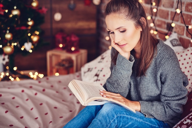 Kostenloses Foto frau, die ein buch im schlafzimmer liest