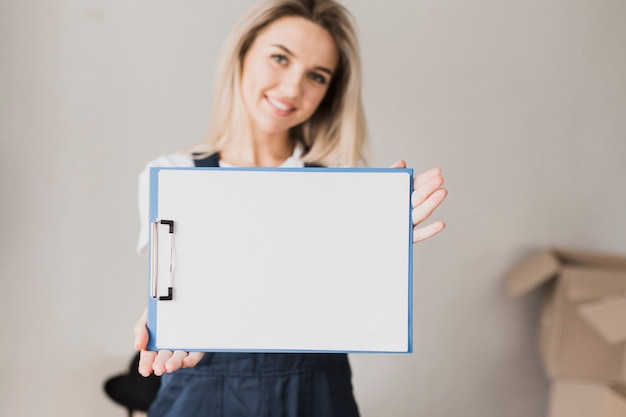 Kostenloses Foto frau, die papierklemmbrett mit modell hält