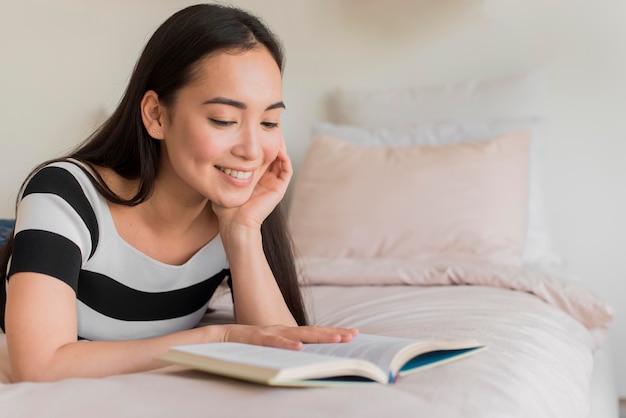 Kostenloses Foto frau im bett lesen