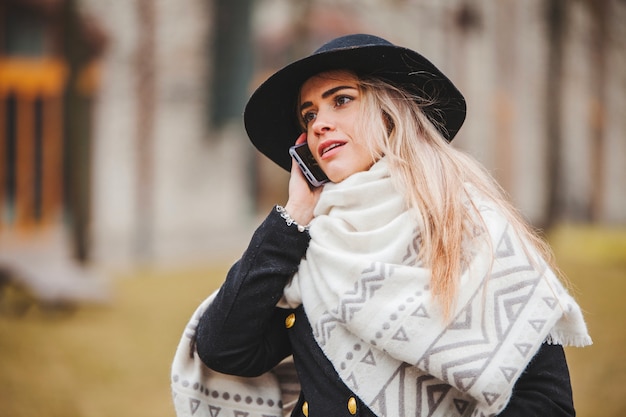 Kostenloses Foto frau mit hut und schal reden am telefon