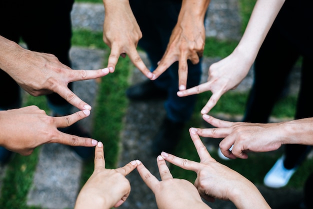 Kostenloses Foto frauen und männerfreunde machen sternform von den fingern. erfolg, freundschaftskonzept.