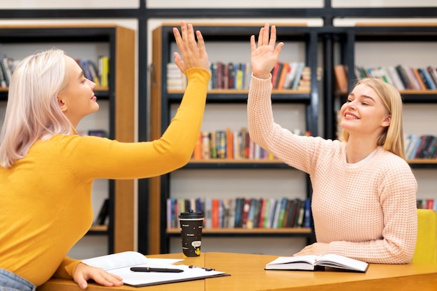 Kostenloses Foto freundinnen high five während der lernsitzung