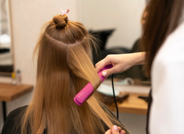 Kostenloses Foto friseur, der die haare eines kunden im salon stylt