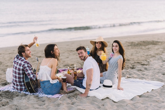 Kostenloses Foto fünf freunde sitzen am strand