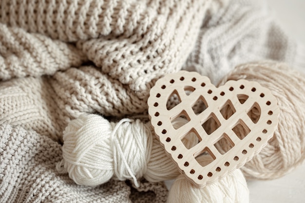 Kostenloses Foto gemütliche komposition mit strickwaren und einem dekorativen holzherz aus nächster nähe.