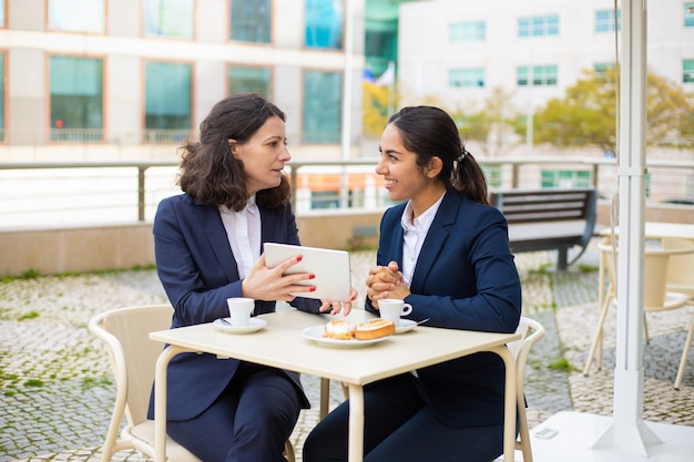 Kostenloses Foto geschäftsfrauen, die kaffee trinken und tablet-pc verwenden