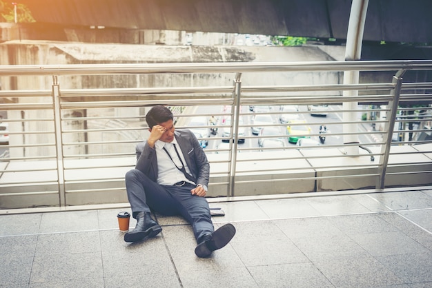 Kostenloses Foto geschäftsmann sitzt auf dem boden betont.