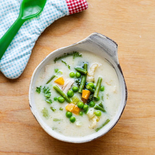 Kostenlose Foto gesunde hühnersuppe für kinder mit erbsen und karotten