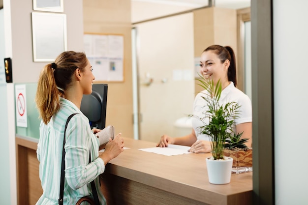 Kostenloses Foto glückliche frau, die mit einer empfangsdame spricht, während sie im spa ankommt