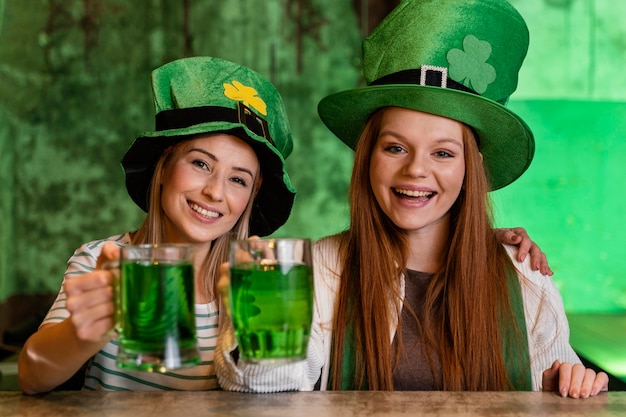 Kostenloses Foto glückliche freundinnen feiern st. patricks tag zusammen mit getränken