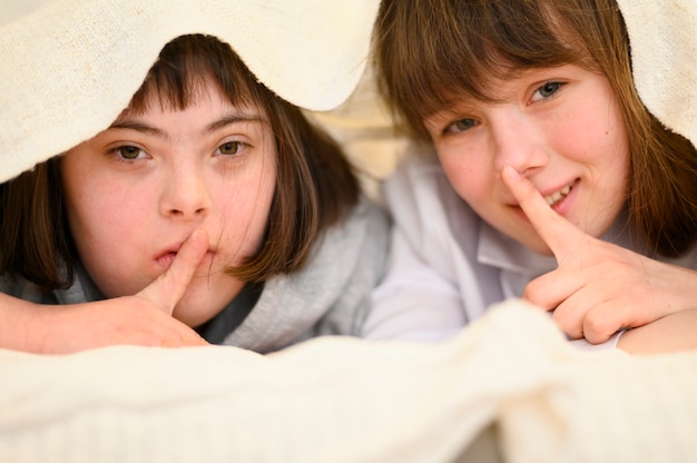 Kostenloses Foto glückliche junge mädchen, die sich zusammen verstecken