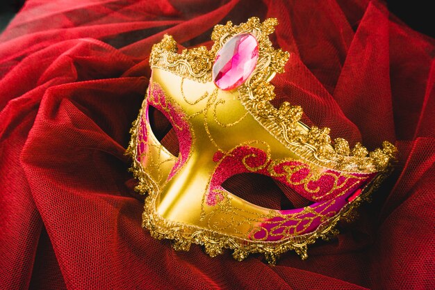 Goldenen venezianischen Maske auf einem roten Stoff