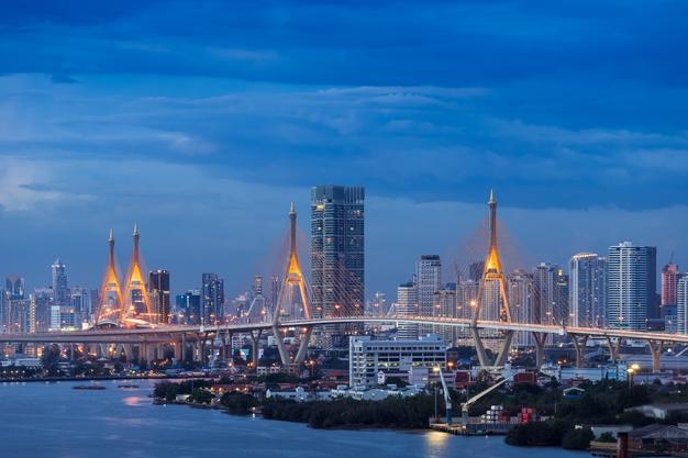 Kostenloses Foto große hängebrücke über den fluss chao phraya in der dämmerung mit stadt im hintergrund