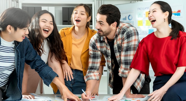 Kostenloses Foto gruppe von asiatischen und kaukasischen jungen kreativen glücklichen genießen lachen lächeln und großen erfolg emotion teamwork menschen geschäftsstart unternehmer lässig brainstorming business meeting bürohintergrund