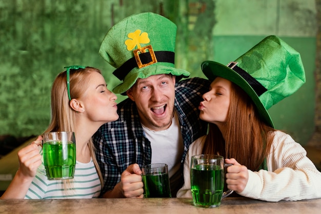 Kostenloses Foto gruppe von freunden feiern st. patricks gemeinsamer tag an der bar