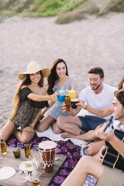 Kostenloses Foto gruppe von freunden sitzen am strand