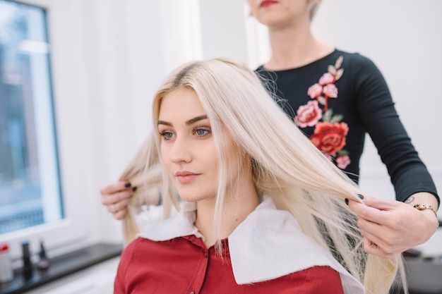 Kostenloses Foto herrenfriseur, der mit blondine im salon arbeitet