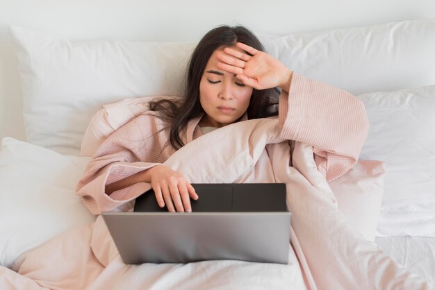 High Angle Frau auf dem Bett mit Laptop