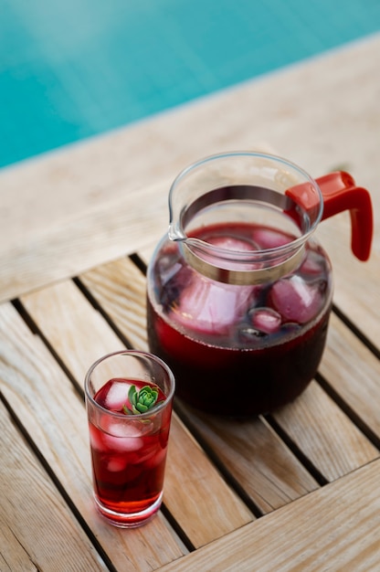 Kostenloses Foto hochwinkeliger köstlicher eistee auf dem tisch am pool