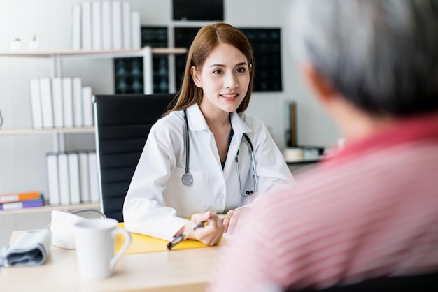 Kostenloses Foto intelligente und attraktive asiatische ärztin erklären und diskutieren mit alten asiatischen männern, um das gesundheitskonzept des klinikhintergrunds zu konsultieren