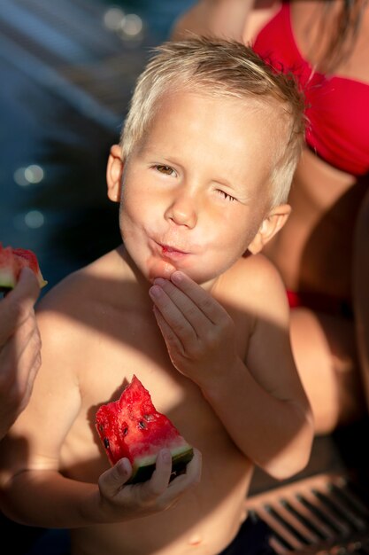 Junge am Schwimmbad mit Wassermelone