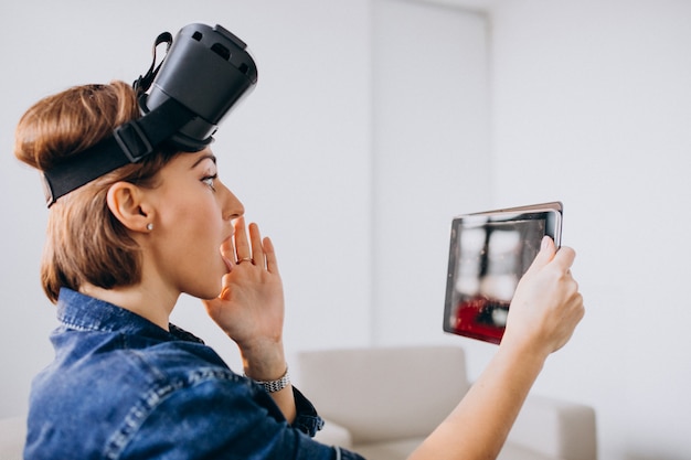 Junge Frau, die vr Gläser trägt und Tablette verwendet