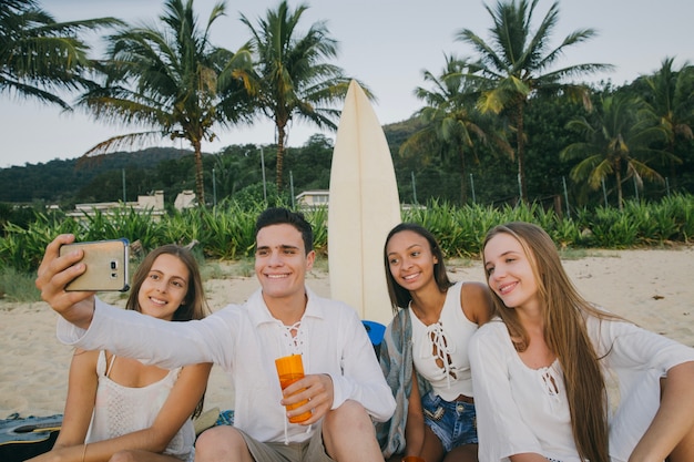 Kostenloses Foto junge freunde nehmen selfie am strand party