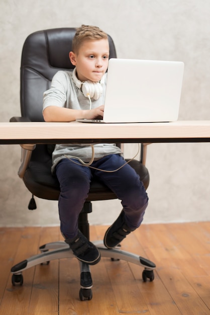 Junge mit Laptop im Büro