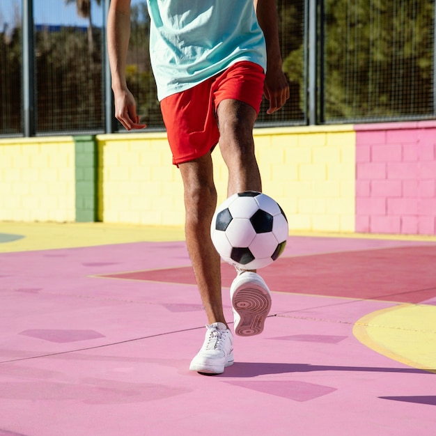 Kostenloses Foto junger mann, der fußball nahaufnahme spielt