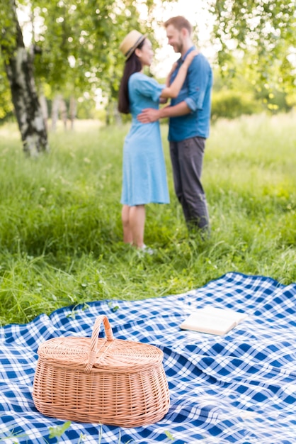 Kostenloses Foto junges glückliches paar, das auf picknick in der natur tanzt