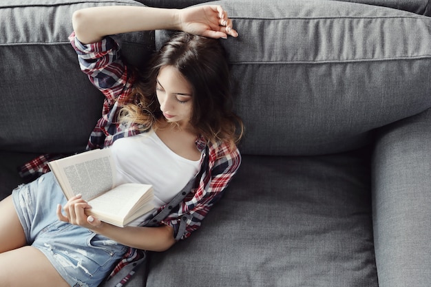 Kostenloses Foto junges teenager-mädchen, das ein buch zu hause liest