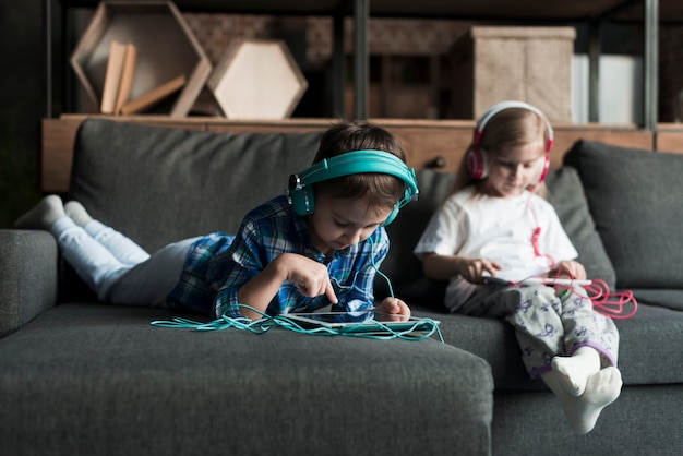 Kostenlose Foto kinder mit tabletten auf der couch