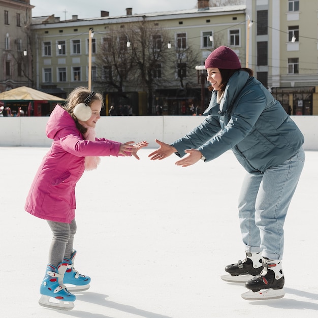 Kostenloses Foto kinder und mutter eislaufen im freien